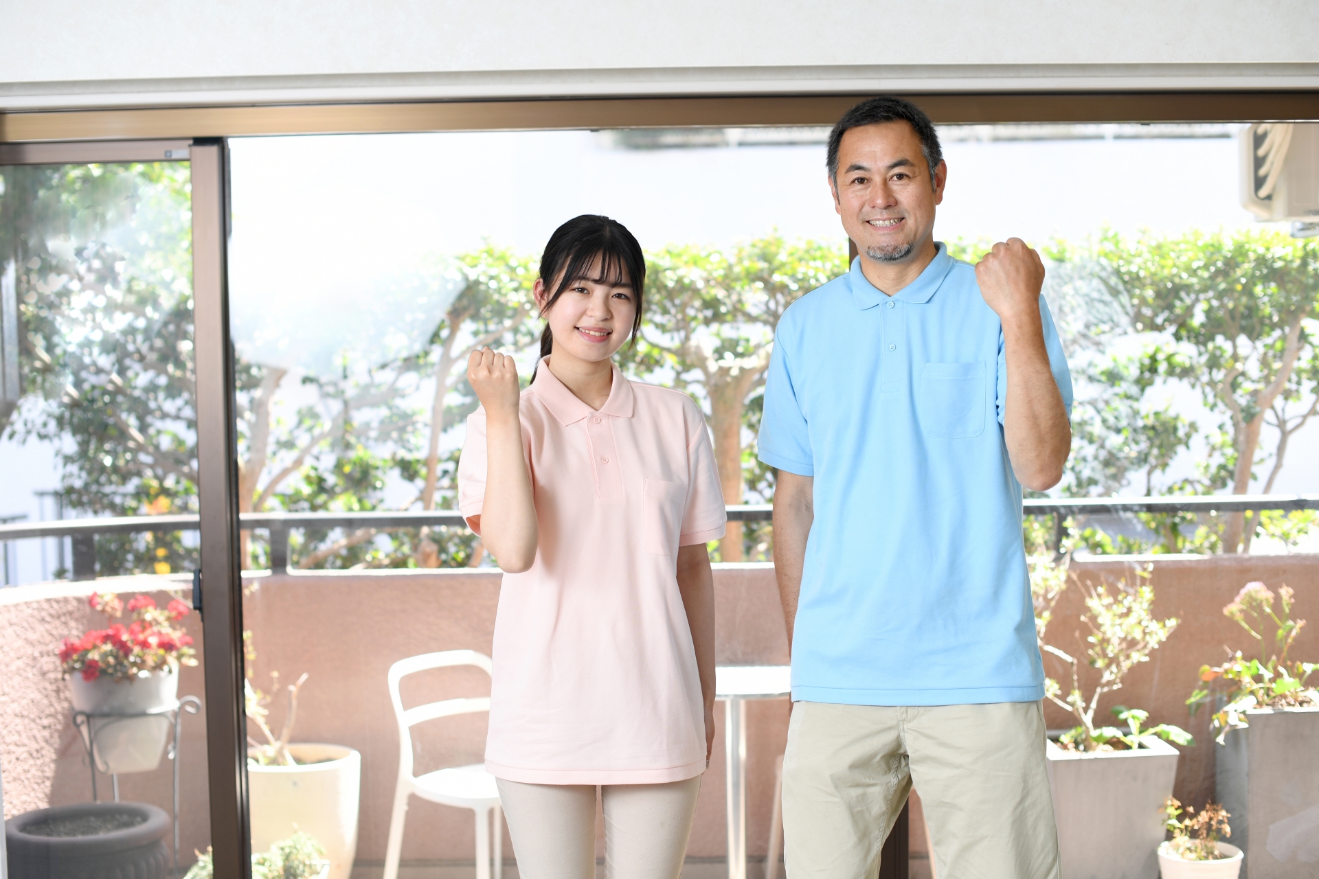 ガッツポーズをする男女の介護スタッフ